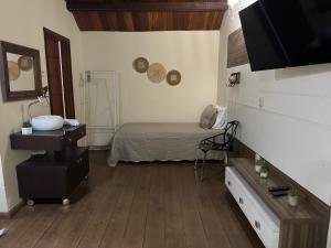 a room with a bed and a sink in it at Chalé 06 com hidro in Itatiaia
