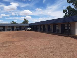 ein großes Gebäude mit einem davor geparkt in der Unterkunft Billabong Hotel Motel in Cunnamulla