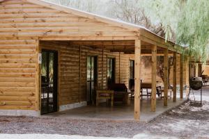 eine Holzhütte mit einem Tisch und einem Grill in der Unterkunft Viñedos de la Luna in Fiambala