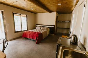 a bedroom with a bed with a red blanket at Viñedos de la Luna in Fiambalá