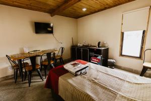 Schlafzimmer mit einem Bett, einem Tisch und einem Schreibtisch in der Unterkunft Viñedos de la Luna in Fiambala