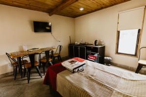 a bedroom with a bed and a table and a desk at Viñedos de la Luna in Fiambala
