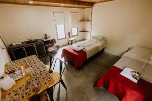 費昂巴拉的住宿－Viñedos de la Luna，一间设有两张床和一张桌子及椅子的房间
