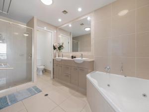 un bagno con vasca, lavandino e doccia di Seabourn Unit 702 Caloundra QLD a Caloundra