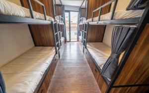 a corridor of a room with several bunk beds at Mad Monkey Hanoi Hostel in Hanoi +86 photos