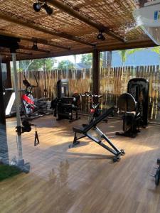 einen Fitnessraum mit Fahrrädern und Trainingsgeräten unter einem Pavillon in der Unterkunft Praia do Forte - COND ALTO DA ENSEADA - Casa 302 in Mata de Sao Joao