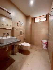 a bathroom with a toilet and a sink at Raghav Bro Stays in Junagadh