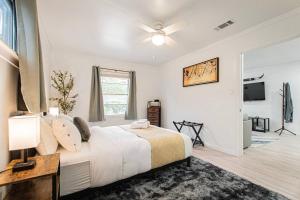 a bedroom with a large bed with a ceiling fan at Downtown Austin Suite Retreat in Austin
