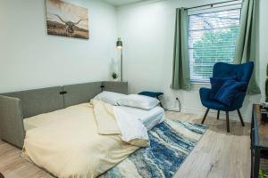 Downtown Austin Suite Retreat في أوستن: غرفة نوم بسرير وكرسي ازرق