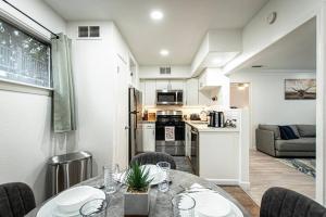 Downtown Austin Suite Retreat في أوستن: مطبخ وغرفة معيشة مع طاولة وكراسي