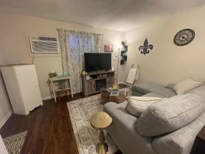 a living room with a couch and a flat screen tv at Bayou Serenity Hideawayfast Wificomfy Bed in Lake Charles