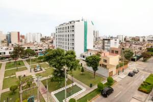 利馬的住宿－LINDA HABITACION PRIVADA EN PUEBLO LIBRE，白色建筑和汽车街道的城市