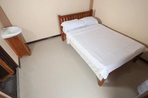 a small bedroom with a bed and a sink at FRIX HOMESTAY and RESTAURANT in Banaue