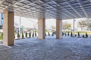 a pavilion with columns and trees in a park at Sokcho Mir Hotel in Sokcho