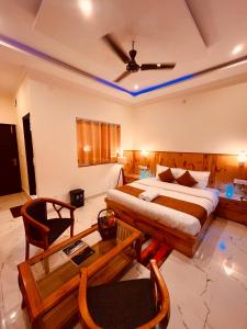 a hotel room with a bed and a table at Siluswar Hotel in Junagadh
