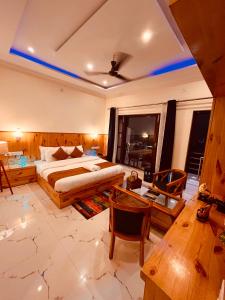 1 dormitorio con 1 cama, mesa y sillas en Siluswar Hotel, en Junagadh