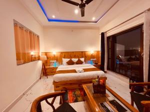 a bedroom with a bed and a table and a window at Siluswar Hotel in Junagadh