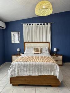 a bedroom with a bed with a blue wall at Casa El Coqui in Luyando