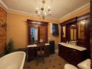 ein Badezimmer mit einer Badewanne, 2 Waschbecken und einem Kronleuchter in der Unterkunft THE RED HOUSE in Niagara Falls