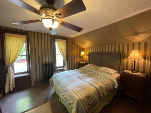 ein Schlafzimmer mit einem Bett und einem Deckenventilator in der Unterkunft THE RED HOUSE in Niagara Falls