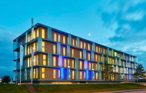 een gebouw met blauwe en paarse lichten erop bij Holiday Inn Express Utrecht - Papendorp, an IHG Hotel in Utrecht