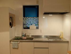 Elle comprend une petite cuisine avec un évier et une fenêtre. dans l'établissement EK House Kamata A, Simple&Stylish, Near Haneda/Shinagawa, one floor, à Tokyo