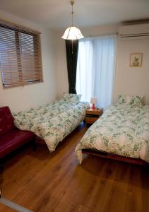 - une chambre avec deux lits et un canapé rouge dans l'établissement EK House Kamata A, Simple&Stylish, Near Haneda/Shinagawa, one floor, à Tokyo