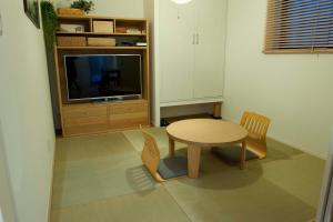 un salon avec une table et une télévision dans l'établissement EK House Kamata A, Simple&Stylish, Near Haneda/Shinagawa, one floor, à Tokyo