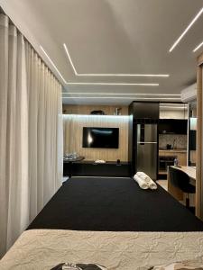 um quarto com uma cama grande e uma cozinha em Quad Studios by Romastay em São Paulo