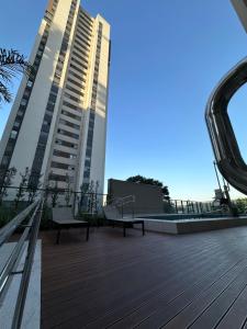 pokład z ławkami i dwa wysokie budynki w obiekcie Quad Studios by Romastay w São Paulo