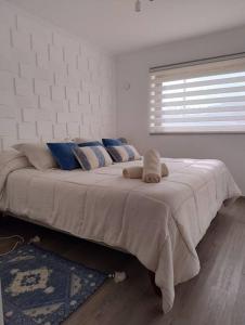 1 dormitorio con 1 cama grande con almohadas y ventana en Nuevo y Maravilloso Dpto. 44m2 en Los Ángeles