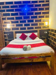 1 dormitorio con 1 cama con 2 zapatillas en Swastik Royal Lodge, en Junagadh