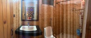 a bathroom with a sink and a toilet and a mirror at Swastik Royal Lodge in Junagadh