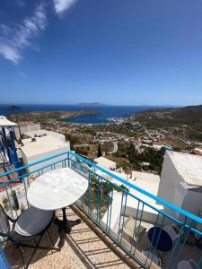 a balcony with a table and chairs and the ocean at School House with Panoramic View in Serifos Chora