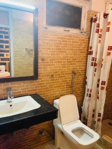 a bathroom with a white toilet and a sink at Swastik Royal Lodge in Junagadh