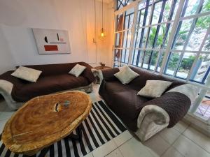 sala de estar con 2 sofás y mesa de madera en casa inca inca, en Gaira