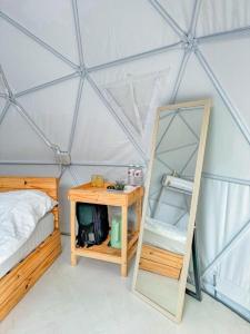 Ban Nong Ka ChaにあるNiNo San Glamping - Pak Chongのベッド1台と鏡付きのテントの部屋