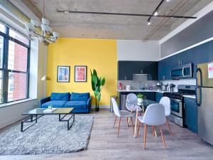 uma sala de estar com um sofá azul e uma cozinha em McCormick 2Br/2Ba family unit for up to 6 guests with Optional Parking & Gym access em Chicago