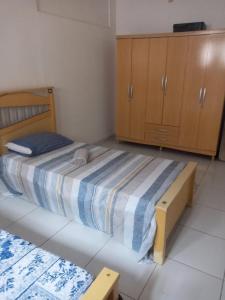 um pequeno quarto com uma cama e armários de madeira em Casa grande mobiliada pra são joao em Campina Grande