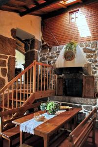 a kitchen with a wooden table and a stone oven at Casa do Forno in Valezim