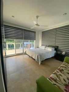 - une chambre avec un lit et une grande fenêtre dans l'établissement Villa Diana-Condominio campestre, à Girardot