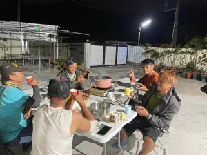 un grupo de personas sentadas alrededor de una mesa con bebidas en 佳林居, en Dahu