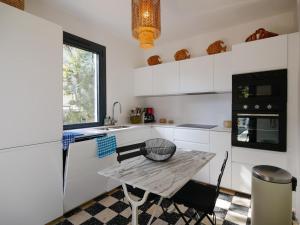 cocina blanca con mesa y fregadero en Villa Sainte-Maxime, 5 pièces, 9 personnes - FR-1-728-17 en Sainte-Maxime