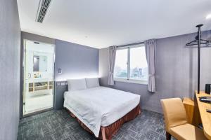 a hotel room with a bed and a window at Hotel Leisure 台中輕行旅 in Taichung