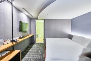 a hotel room with a bed and a television at Hotel Leisure 台中輕行旅 in Taichung