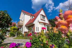 a white house with a red roof and flowers at Yishin Garden B&B in Pinghe