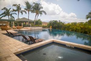 una piscina con 2 tumbonas y palmeras en ENDLESS OCEAN VIEWS Abundant 3BR Waiulaula Home with Endless Ocean Views en Hapuna Beach