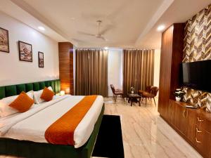 Habitación de hotel con cama y TV de pantalla plana. en Sanju Valley View en Jamnagar