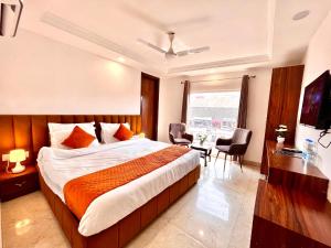 Habitación de hotel con cama, mesa y sillas en Sanju Valley View en Jamnagar