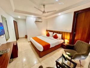 Habitación de hotel con cama y silla en Sanju Valley View en Jamnagar